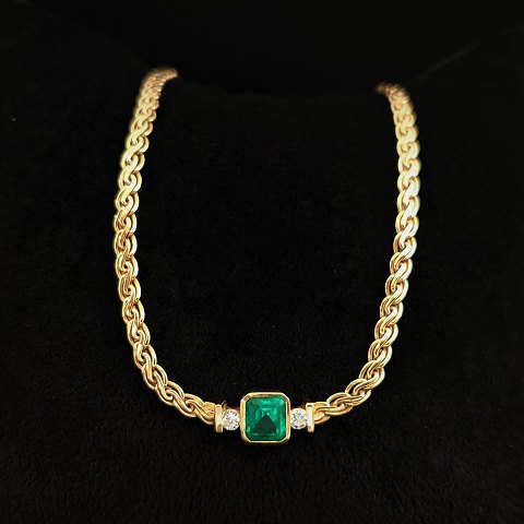 A 18k gold necklace set with an emerald and two brillants