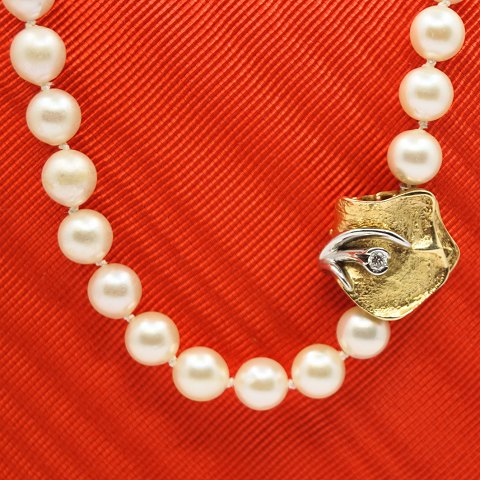 Ole Lynggaard; A pearl necklace with clasp of 14k gold with a diamond