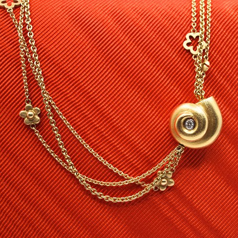 Ole Lynggaard; A diamond snail clasp of 18k gold, chain 14k gold